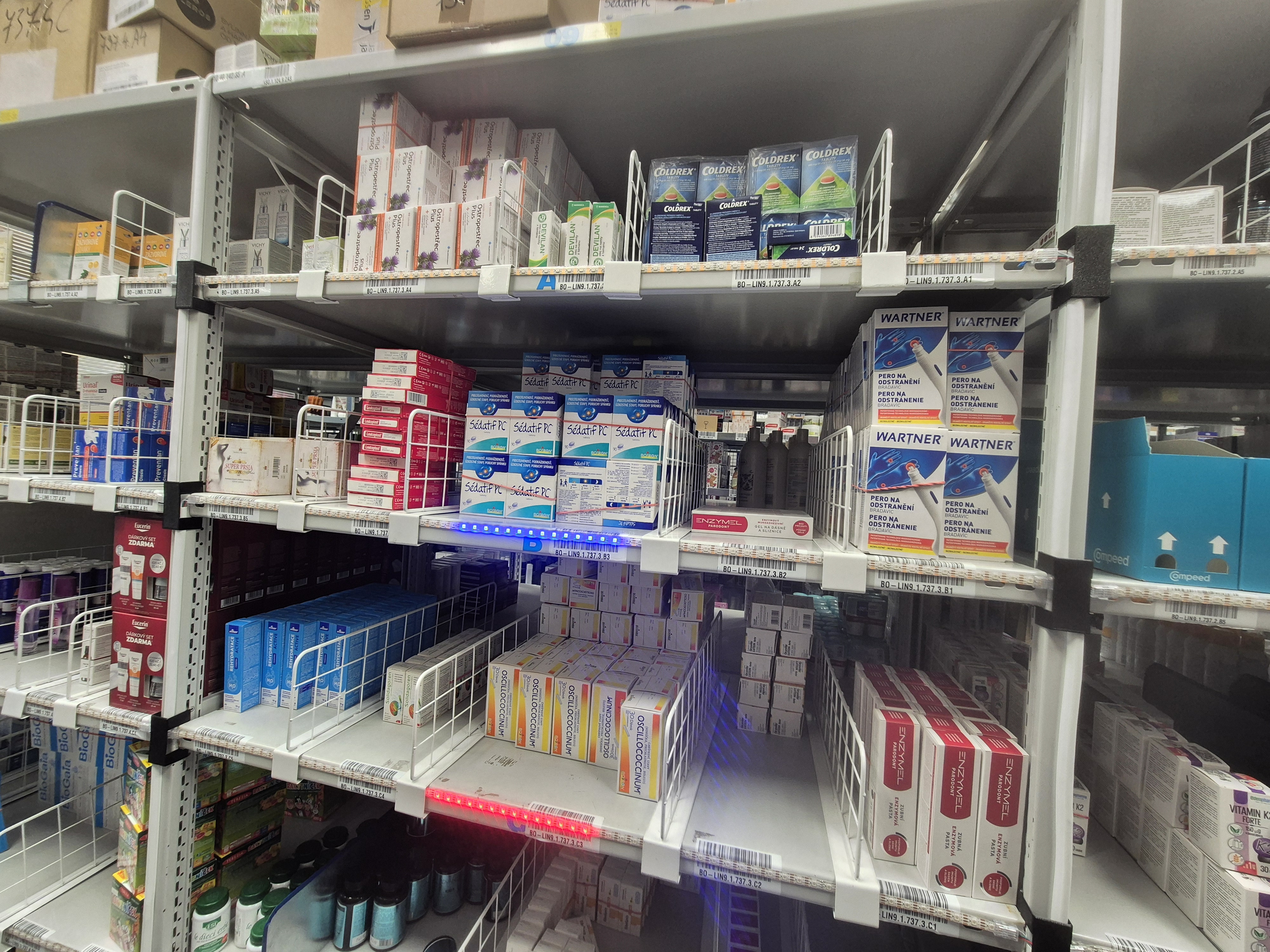 LED pásy na skladových regáloch s modrým a červeným svetlom na vybraných pozíciách